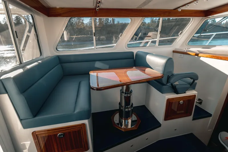 Slide: The Image of 2025 Lindell 38' boat deck with storage compartments, docked by calm water. - 4