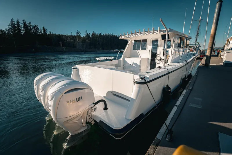 Slide: The Image of Sleek 2027 Lindell 38' boat deck with storage compartments, docked by serene waters. - 8