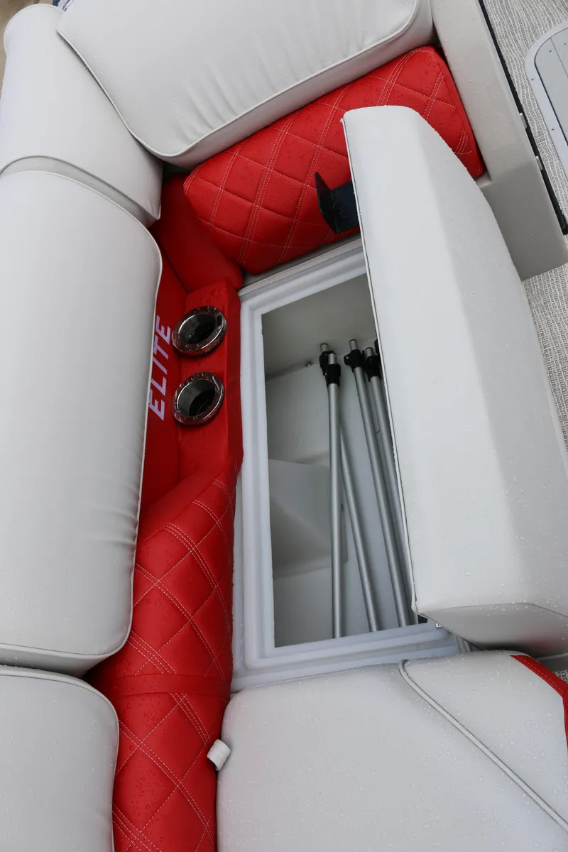 Slide: The Image of 2025 SunCatcher Elite 324 RC boat interior with red and white seating and storage compartment. - 10