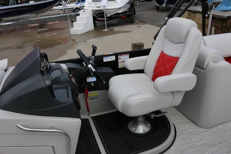 Slide: The Image of 2025 SunCatcher Elite 324 RC boat interior with steering console and plush captain's chair. - 17