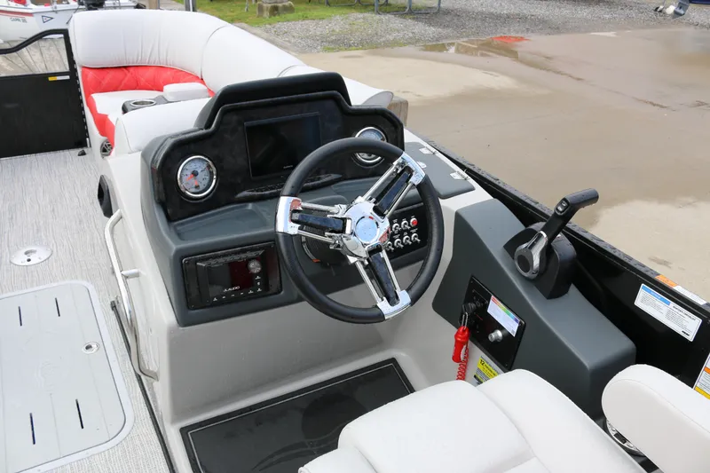 Slide: The Image of 2025 SunCatcher Elite 324 RC boat dashboard with steering wheel and controls. - 18
