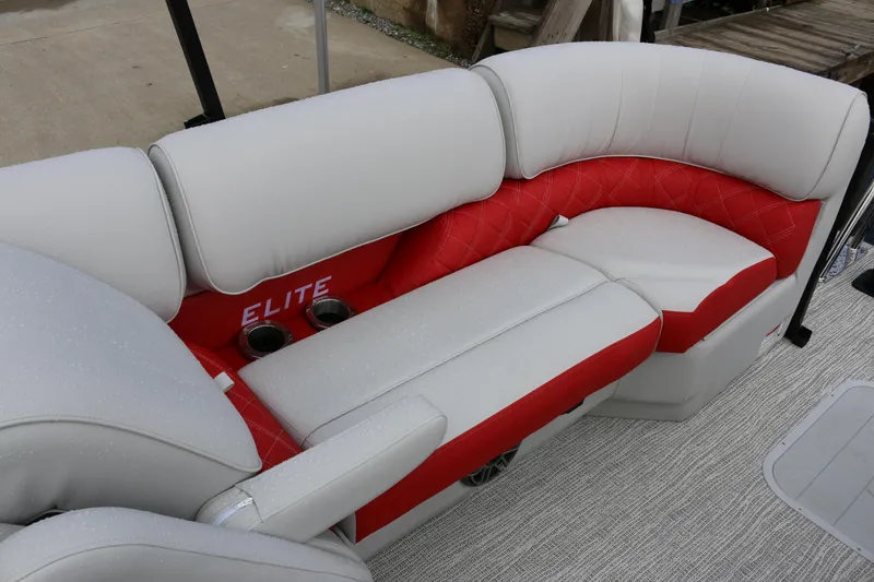 Slide: The Image of 2025 SunCatcher Elite 324 RC boat seating with red and white upholstery, featuring cup holders. - 22