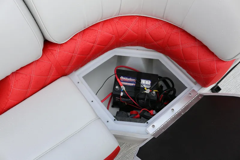 Slide: The Image of 2025 SunCatcher Elite 324 RC boat seat storage with battery compartment, featuring red and white upholstery. - 25