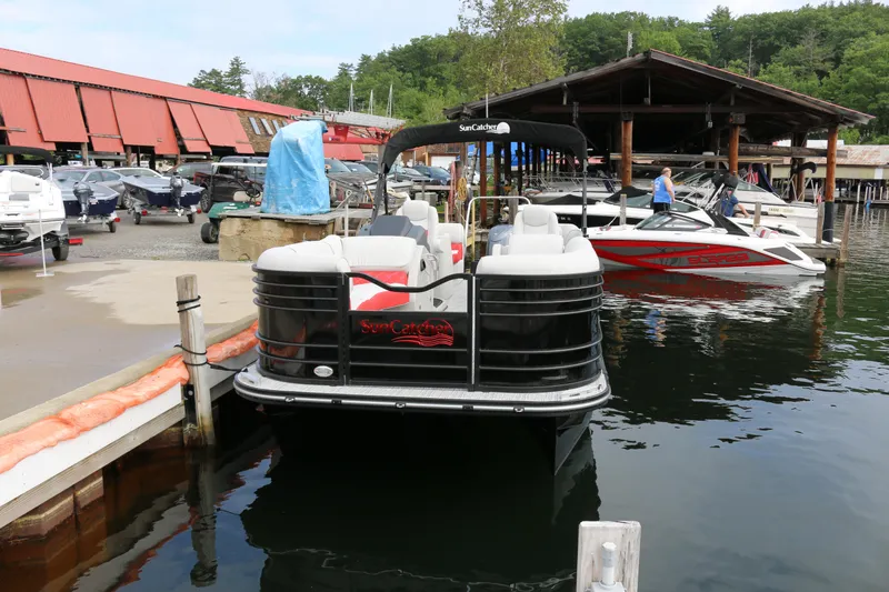 Slide: The Image of 2025 SunCatcher Elite 324 RC pontoon boat docked at a marina with other boats. - 37