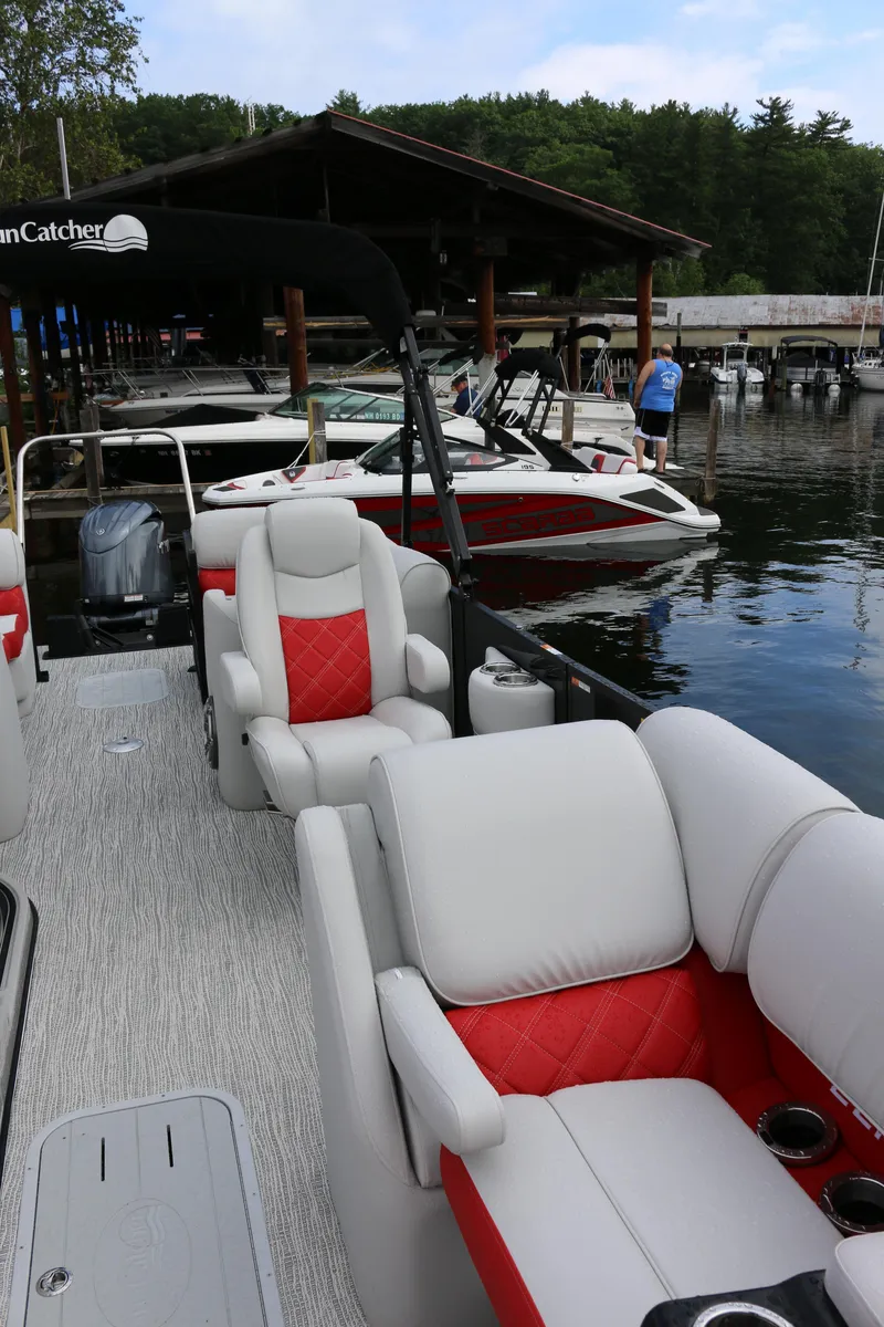 Slide: The Image of 2025 SunCatcher Elite 324 RC boat with luxurious seating at a marina. - 5