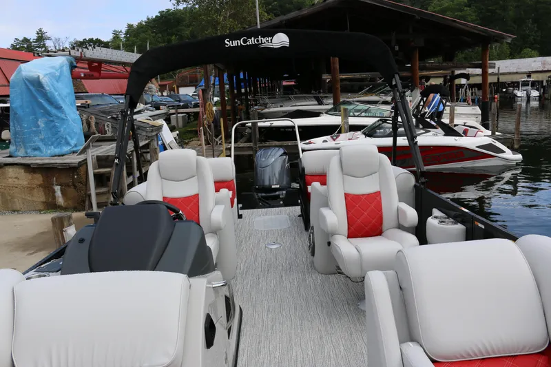 Slide: The Image of 2025 SunCatcher Elite 324 RC pontoon boat with luxurious seating at a marina. - 7
