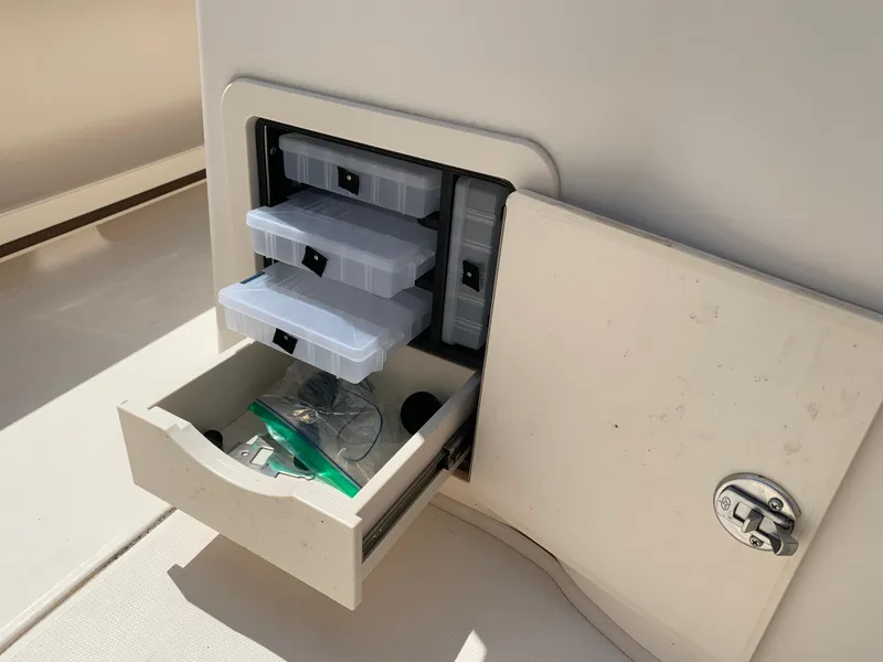 Slide: The Image of Storage compartment with tackle boxes on a 2020 Grady-White 236 Fisherman boat. - 18