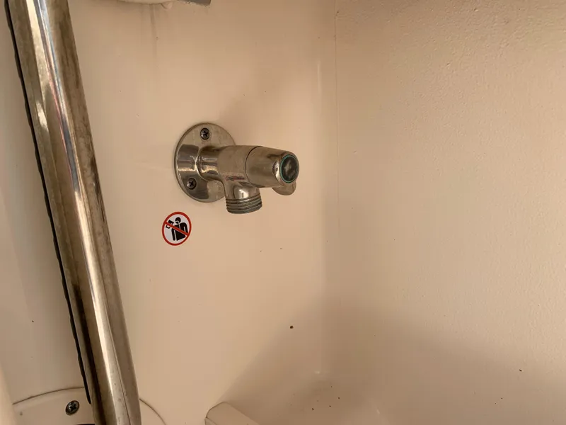 Slide: The Image of Boat interior detail of a 2020 Grady-White 236 Fisherman, featuring a metal fitting and warning sticker. - 33