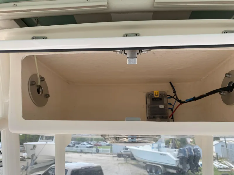 Slide: The Image of Open storage compartment on a 2020 Grady-White 236 Fisherman boat, showing wiring and components. - 37
