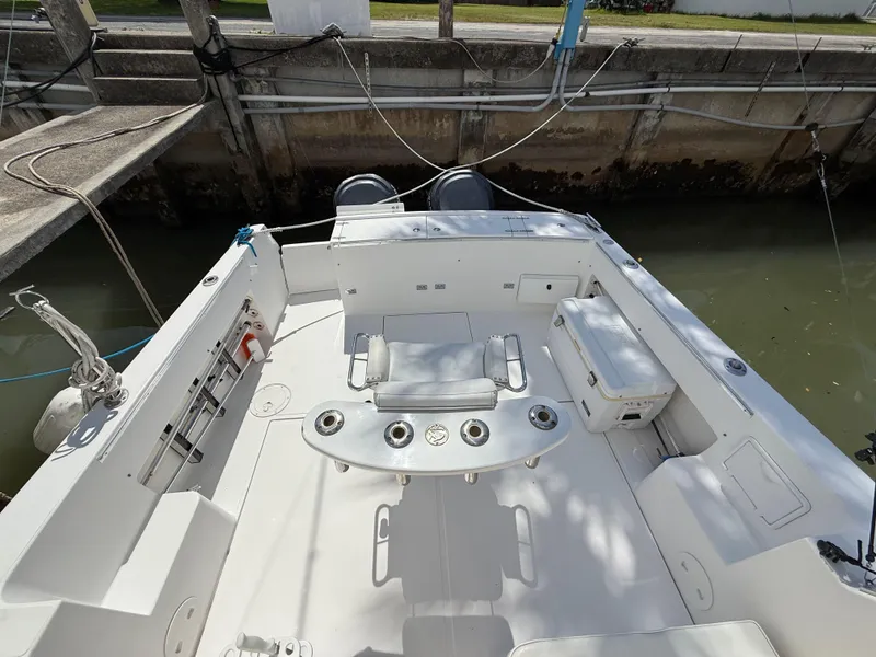 Slide: The Image of 2004 Stamas 320 Express boat interior with seating and fishing rod holders at dock. - 10