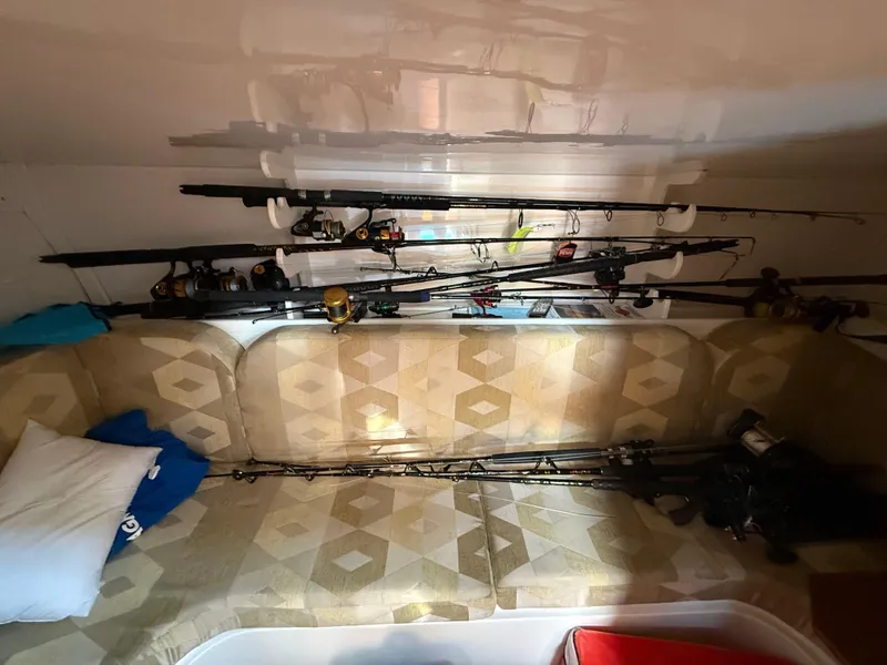 Slide: The Image of Interior of 2004 Stamas 320 Express with fishing rods and patterned seating. - 13