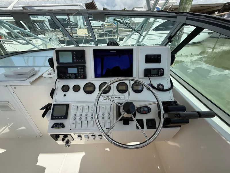 Slide: The Image of 2004 Stamas 320 Express boat dashboard with navigation instruments and steering wheel. - 4