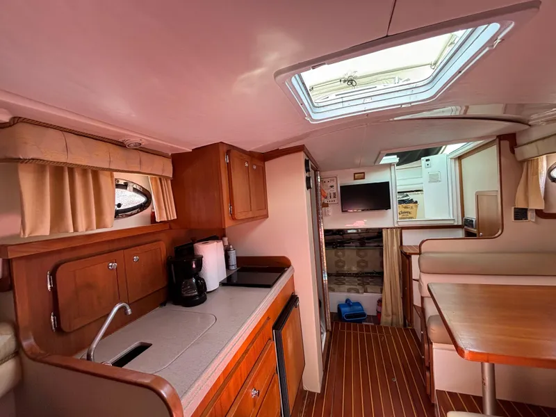 Slide: The Image of 2004 Stamas 320 Express cabin interior with kitchenette, dining area, and skylight. - 5