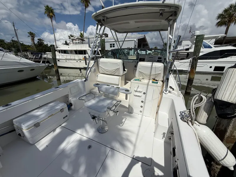Slide: The Image of 2004 Stamas 320 Express boat docked, featuring spacious deck and seating under a clear sky. - 6