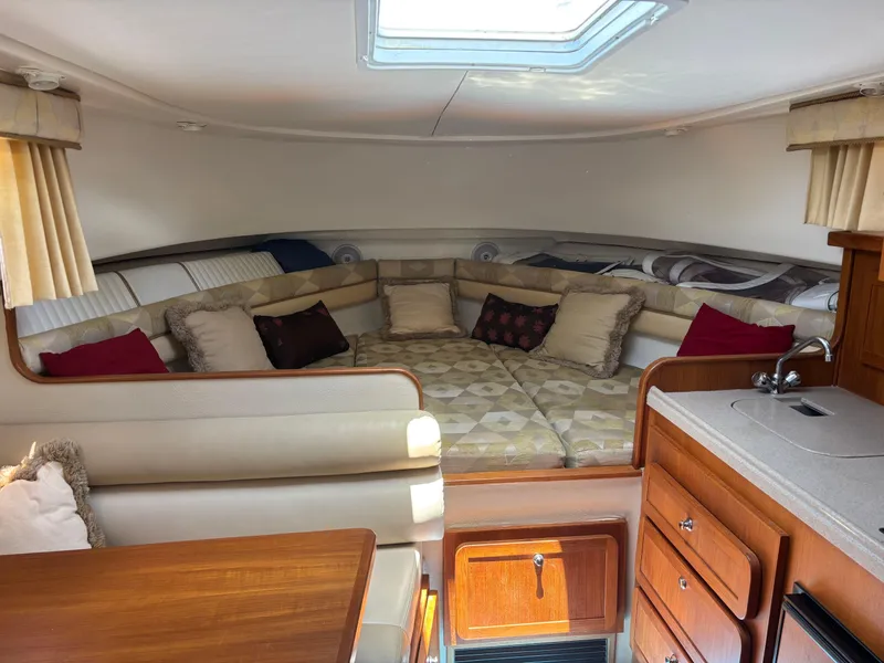 Slide: The Image of 2004 Stamas 320 Express cabin interior with cozy seating, cushions, and kitchenette. - 8