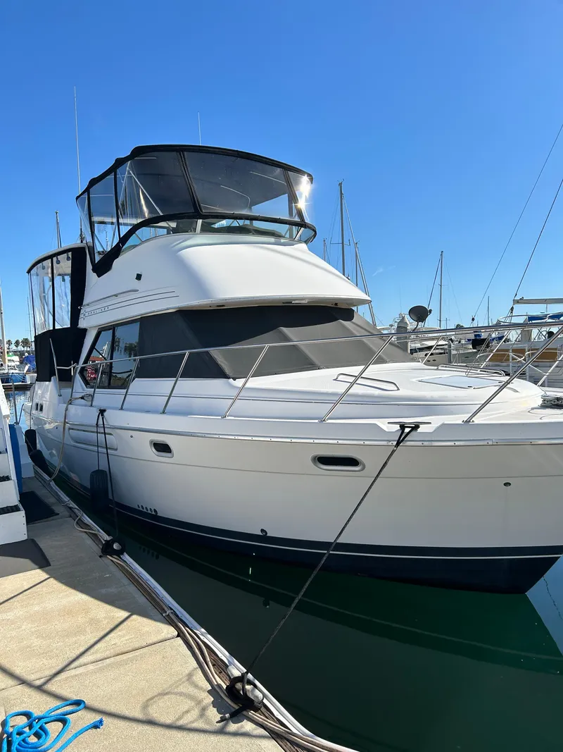 The Image of 1996 Bayliner 4087 Aft Cabin Motoryacht docked at marina under clear blue sky. - 0