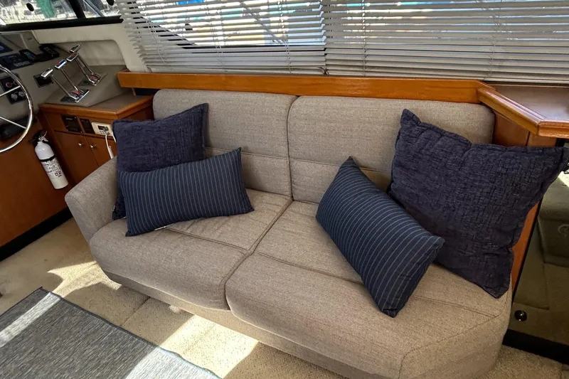 Slide: The Image of 1996 Bayliner 4087 Aft Cabin Motoryacht interior with beige sofa and blue cushions. - 10