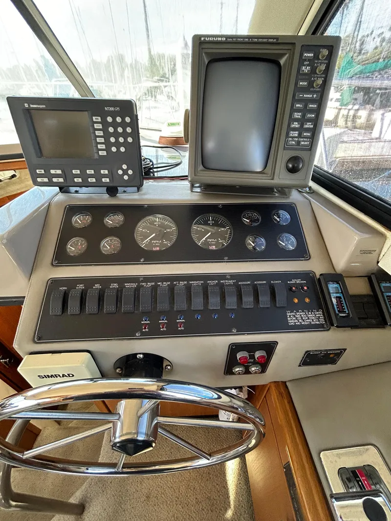 Slide: The Image of 1996 Bayliner 4087 Aft Cabin Motoryacht helm with navigation instruments and steering wheel. - 21