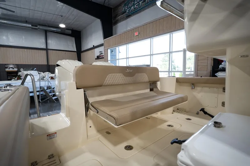 Slide: The Image of 2025 Scout 260 LXF boat interior with beige seating in a showroom. - 13