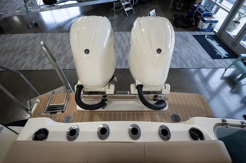 Slide: The Image of 2025 Scout 260 LXF boat with dual outboard engines in showroom. - 14