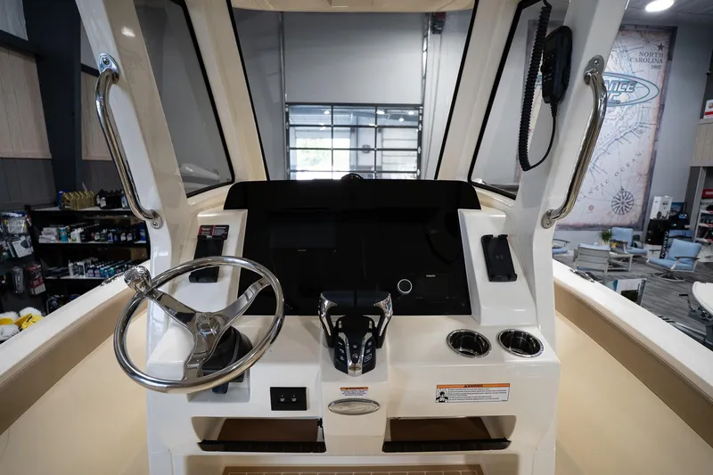 Slide: The Image of 2025 Scout 260 LXF boat dashboard with steering wheel and controls in showroom. - 17