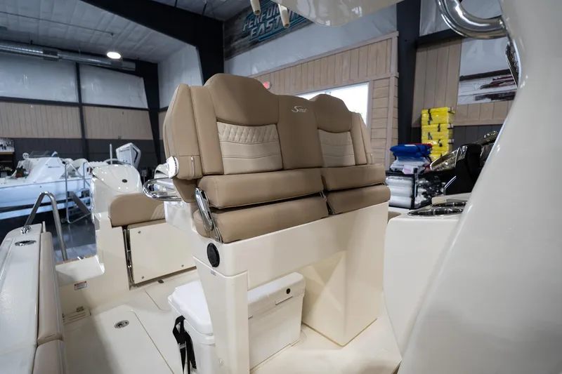 Slide: The Image of 2025 Scout 260 LXF boat interior with beige seating in showroom. - 20