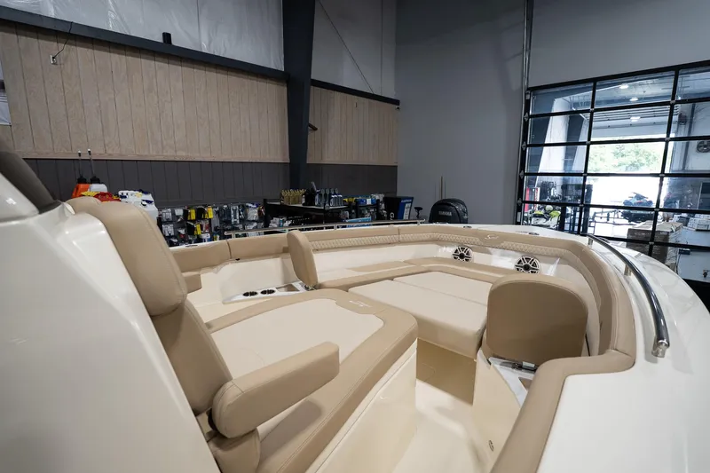 Slide: The Image of 2025 Scout 260 LXF boat interior with beige seating in a showroom. - 21