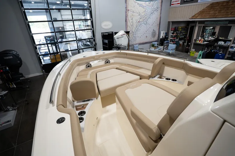 Slide: The Image of 2025 Scout 260 LXF boat interior with beige seating and modern design in showroom. - 23