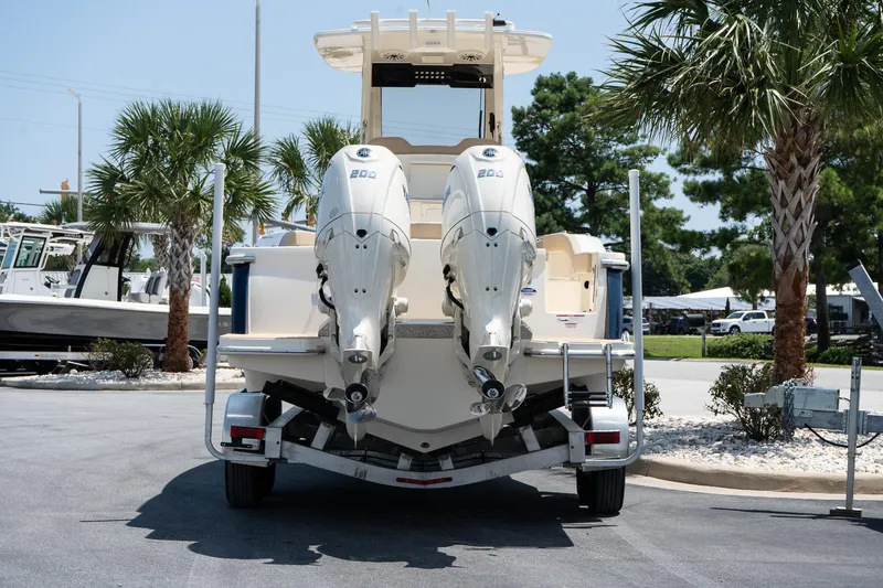Slide: The Image of 2026 Scout 260 LXF boat on trailer, dual engines, parked near palm trees. - 4