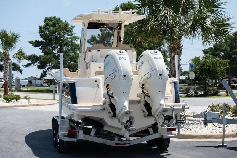Slide: The Image of 2026 Scout 260 LXF boat with dual engines on a trailer, parked outdoors. - 5