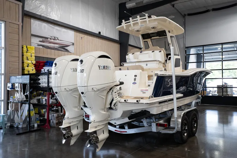 Slide: The Image of 2025 Scout 260 LXF boat with dual Yamaha engines in a showroom. - 9