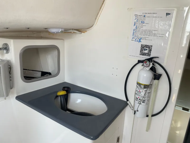 Slide: The Image of Interior of 2014 J Boats J 88 with sink, fire extinguisher, and checklist. - 16