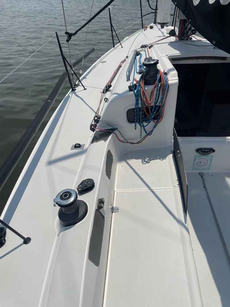 Slide: The Image of 2014 J Boats J 88 sailboat deck with winches and rigging, docked on calm water. - 5