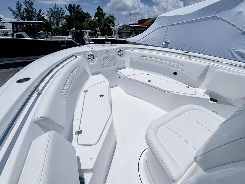 Slide: The Image of 2026 Tidewater 232 CC Adventure boat interior with white seating and storage compartments. - 13