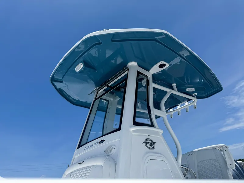 Slide: The Image of 2026 Tidewater 232 CC Adventure boat with blue T-top against clear sky. - 3