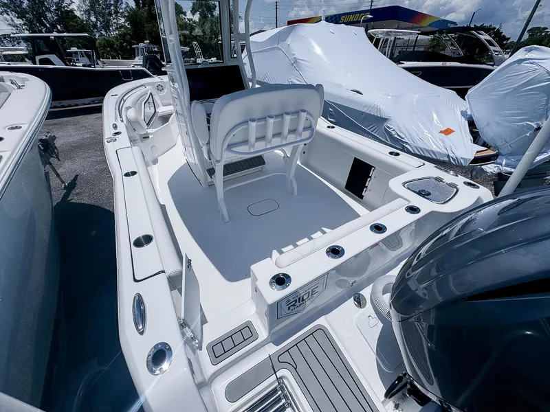 Slide: The Image of 2026 Tidewater 232 CC Adventure boat interior with seating and fishing rod holders. - 5