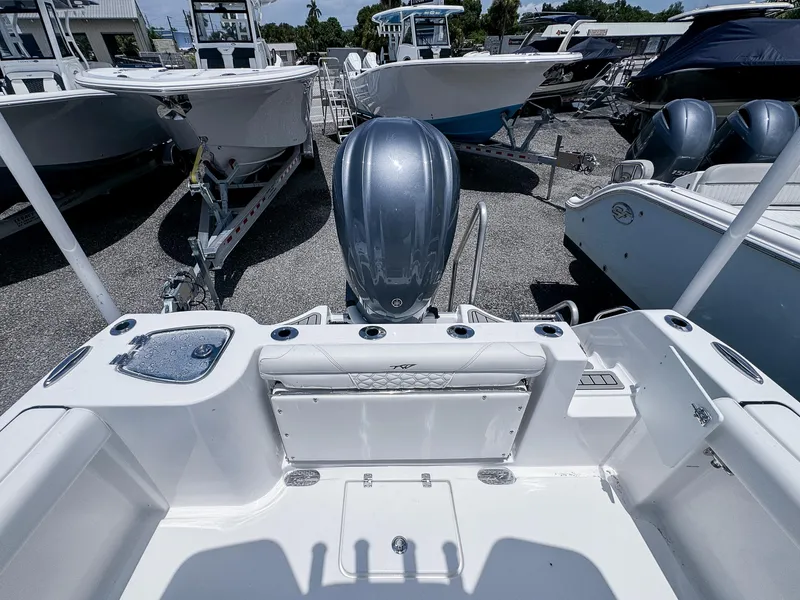 Slide: The Image of 2026 Tidewater 232 CC Adventure boat, rear view with motor, in a marina setting. - 6