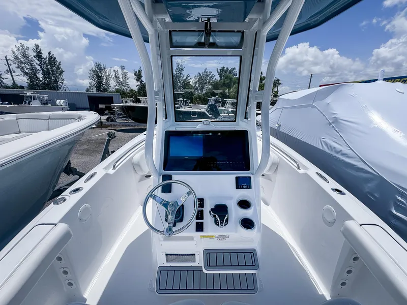 Slide: The Image of 2026 Tidewater 232 CC Adventure boat console with steering wheel and navigation display. - 8