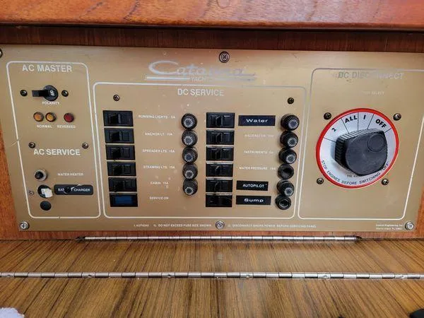 Slide: The Image of Control panel of a 1986 Catalina 30 sailboat, featuring AC and DC service switches. - 13