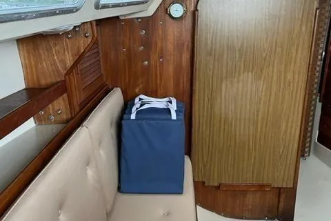 Slide: The Image of Interior of 1986 Catalina 30 sailboat with blue bag on beige seat. - 14