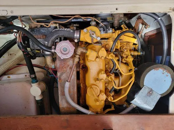 Slide: The Image of Engine compartment of a 1986 Catalina 30 sailboat, showcasing a yellow marine engine. - 15