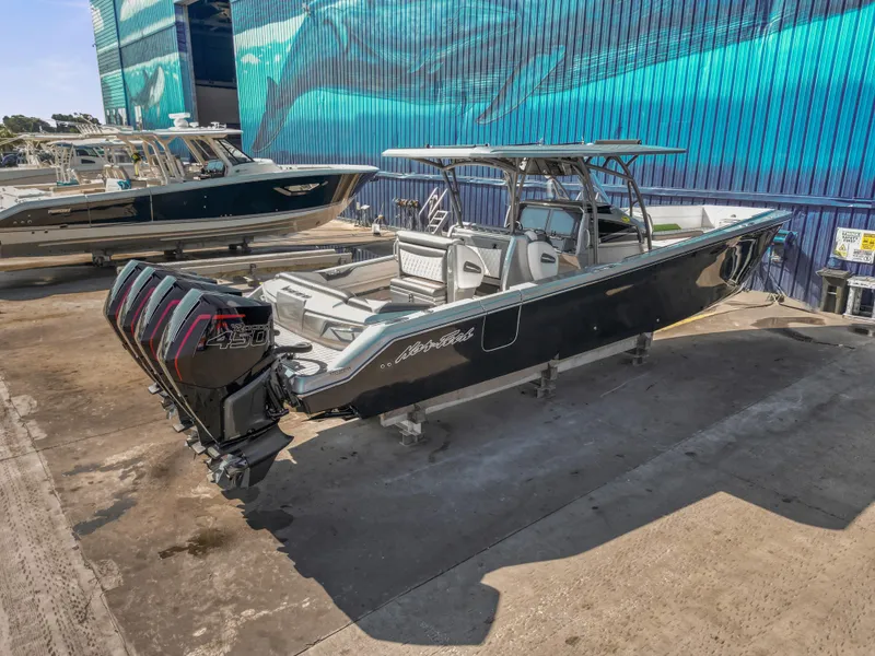 Slide: The Image of 2021 Nor-Tech 390 Sport Center Console boat with quad engines in a marina setting. - 11