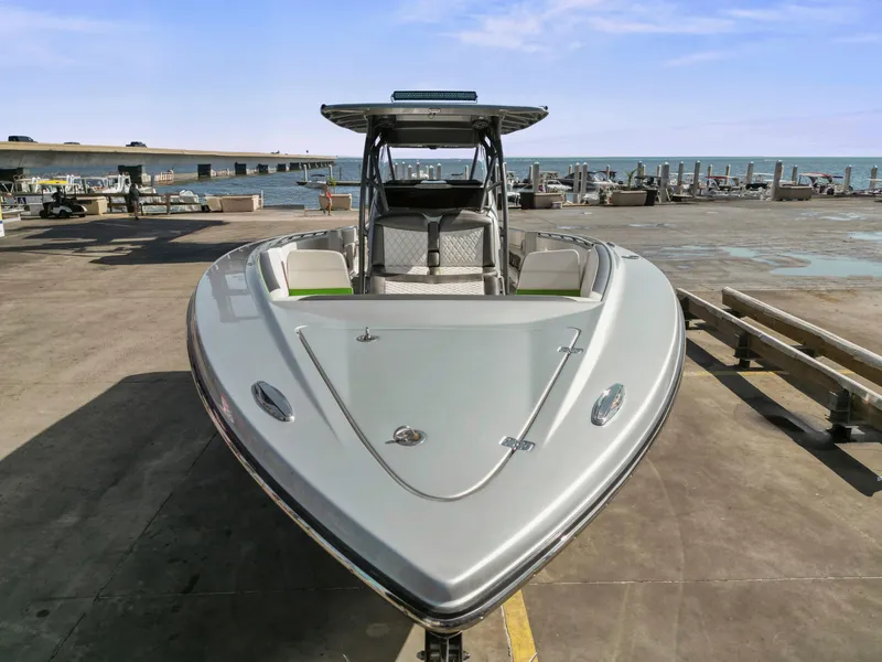 Slide: The Image of 2021 Nor-Tech 390 Sport Center Console boat docked by the waterfront. - 12