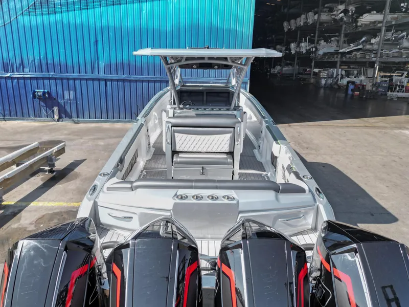 Slide: The Image of 2021 Nor-Tech 390 Sport Center Console boat with multiple engines, docked in a marina. - 19