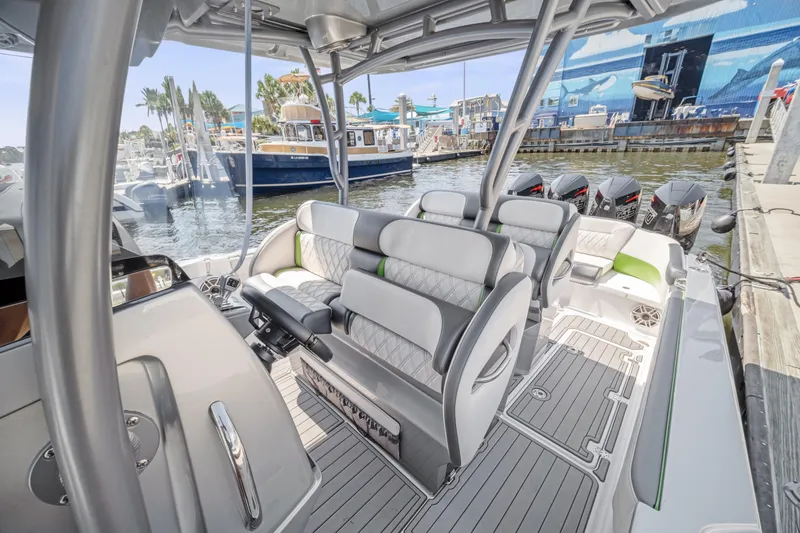 Slide: The Image of 2021 Nor-Tech 390 Sport Center Console boat interior with seating and multiple outboard engines. - 25