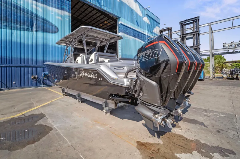 Slide: The Image of 2021 Nor-Tech 390 Sport Center Console boat with triple outboard engines, docked outdoors. - 31