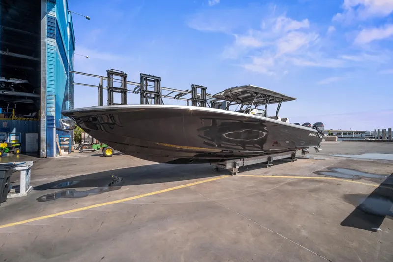 Slide: The Image of 2021 Nor-Tech 390 Sport Center Console boat on dry dock under clear blue sky. - 32