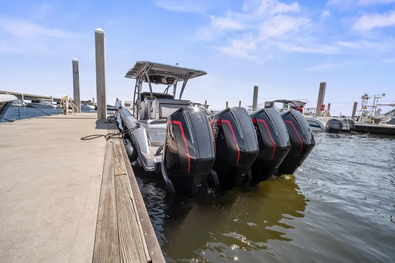 Slide: The Image of 2021 Nor-Tech 390 Sport Center Console docked with four powerful outboard engines. - 33