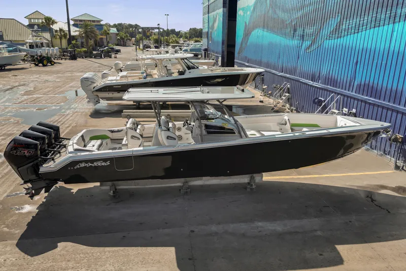 Slide: The Image of 2021 Nor-Tech 390 Sport Center Console boat with triple engines, docked outdoors. - 43