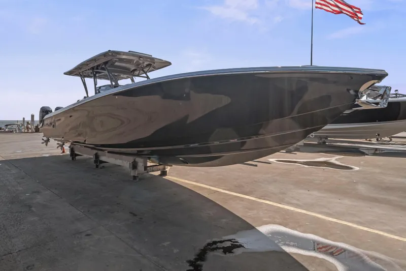 Slide: The Image of 2021 Nor-Tech 390 Sport Center Console boat on a dock with American flag. - 44